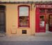 a yellow building with a red door and window
